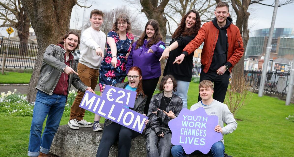 A group of young people holding a sign that says '21 million euro'.