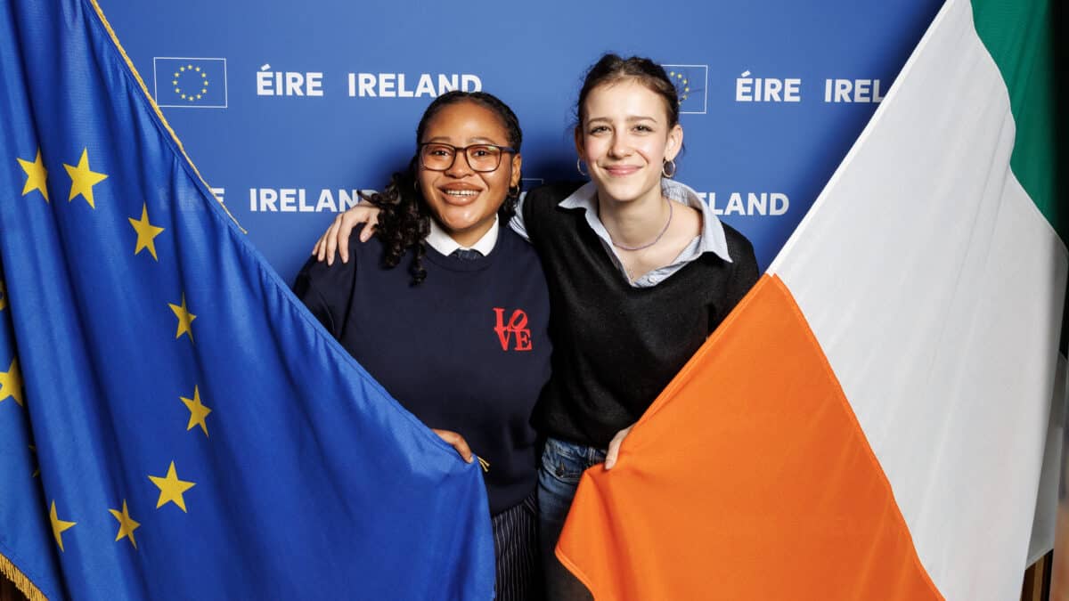 Young people holding EU flag and Ireland flag.